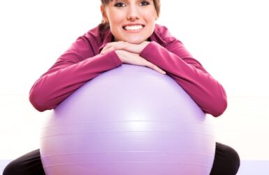 Happy woman leaning on yoga ball