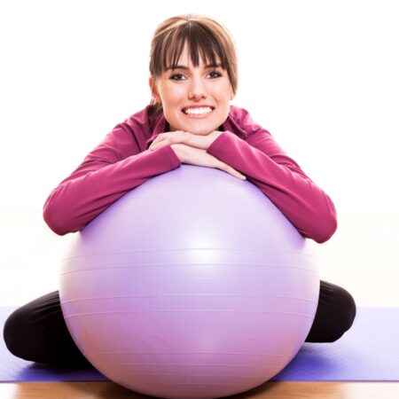 Happy woman leaning on yoga ball