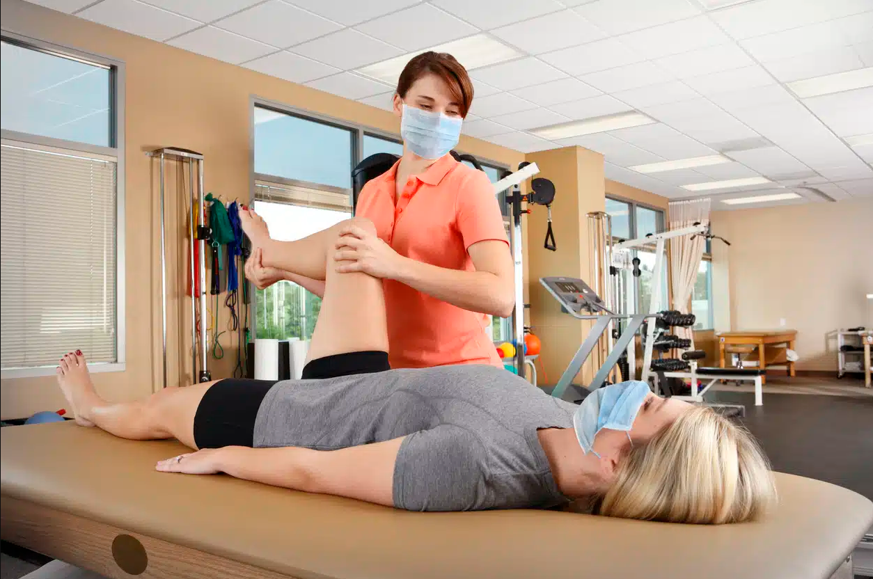A physical therapist assisting a patient with knee exercises