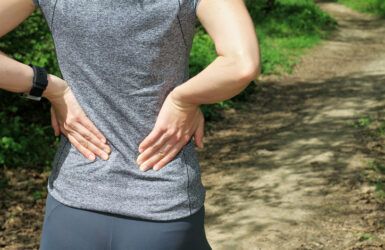 Back Pain. Woman rubbing the muscles of her lower back.