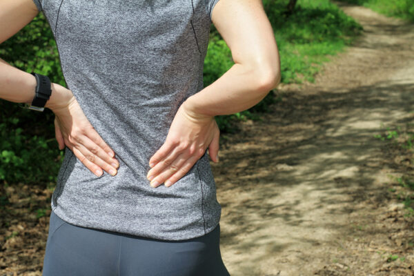 Back Pain. Woman rubbing the muscles of her lower back.