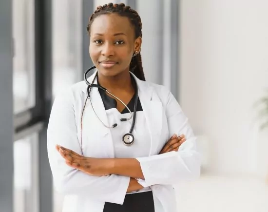 Portrait of female African American doctor standing in her office at clinic Portrait of female African American doctor standing in her office at clinic
