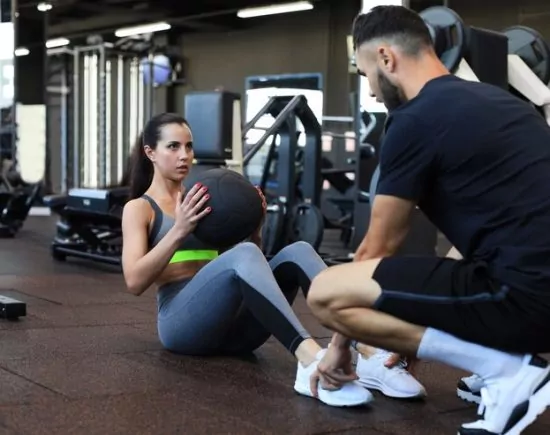 Trainer helping young woman Trainer helping young woman